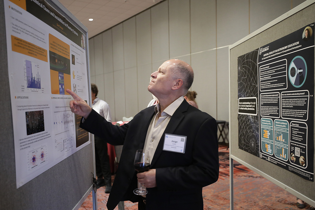 person pointing to a scientific poster on an easel at the 2026 Cottrell Scholars Conference